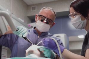 Dentist performing root canal with a dental assistant