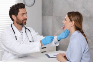 Oral Biome testing - dentist swabbing mouth of adult woman