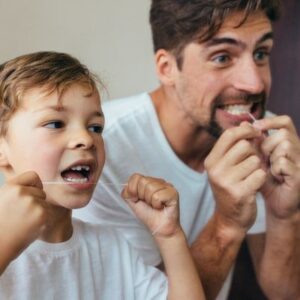 Father and Son Flossing Teeth