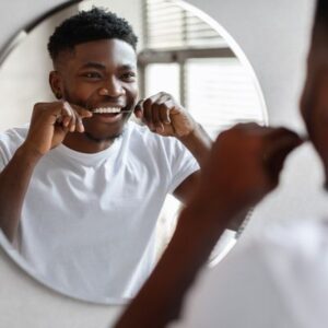 Young Man flossing his teeth