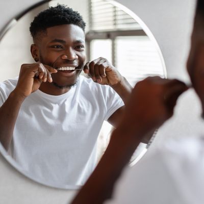 Young Man flossing his teeth